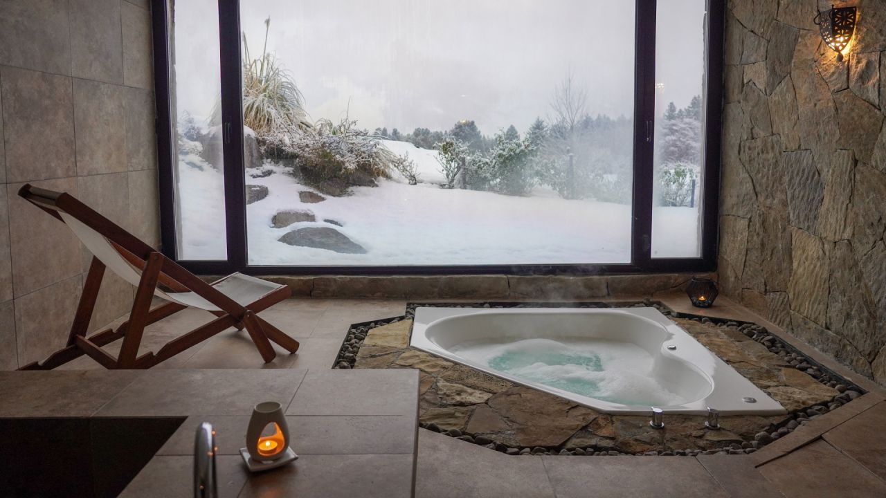 Jacuzzi del Spa Namasthé de Loi Suites Chapelco con vista a la nieve.